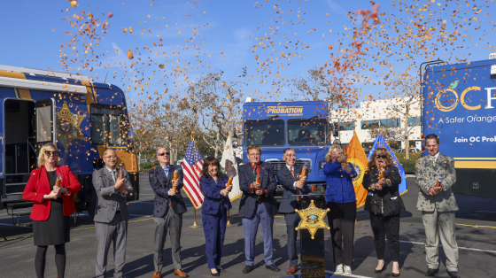 Chief probation officer and dignitaries launch confetti cannons at a press conference for new mobile resource vehicles